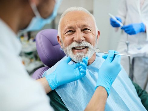 a patient smiling after receiving dentures in Garland