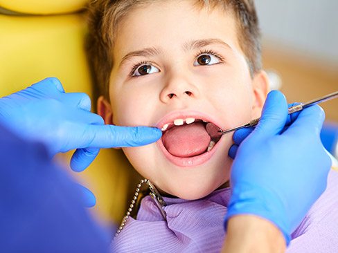 Young boy receiving dental checkup and teeth cleaning