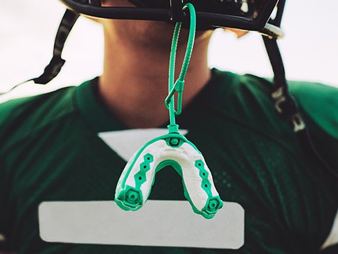 Mouthguard hanging from football helmet