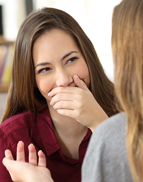 Woman covering her mouth before cosmetic dentistry