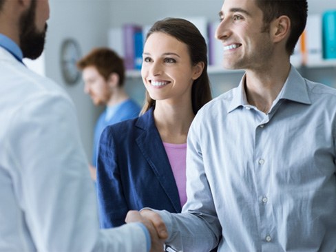 Male patient shaking hands with cosmetic dentist in Garland