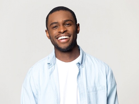 man in light blue shirt smiling brightly