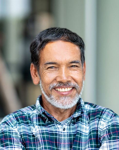 An older man with dentures smiling