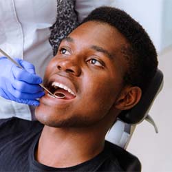 Man leaning back in chair visiting emergency dentist in Garland, TX
