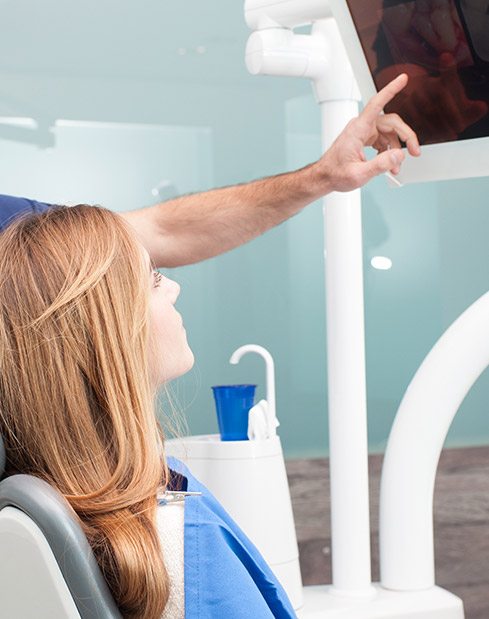 Dentist and patient looking at dental x-rays before tooth extractions