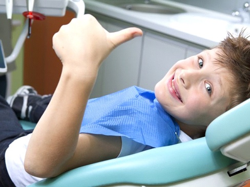 A child giving a thumbs-up at his dental appointment