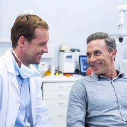 Implant dentist in Garland speaking with a patient