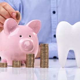 tooth and piggy bank for cost of dental implants in Garland