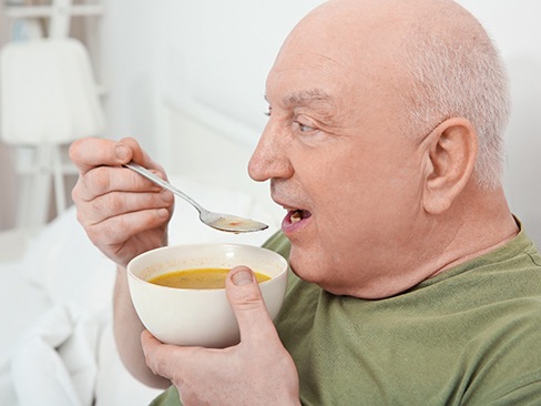 An older man having soup as a meal