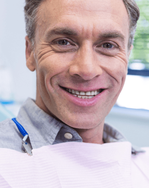 Man sitting in dental chair and smiling