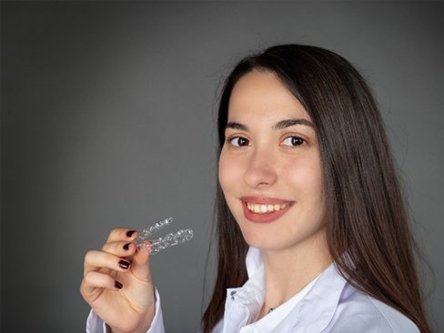 Woman holding an Invisalign tray