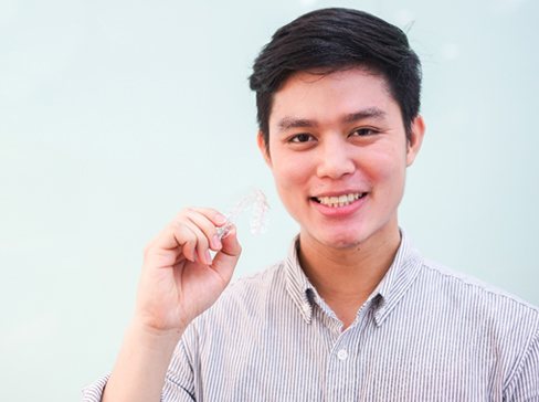 Man holding an Invisalign tray