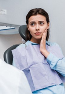 Woman with toothache talking to emergency dentist