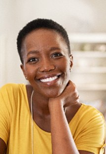 Woman in yellow shirt smiling in living room