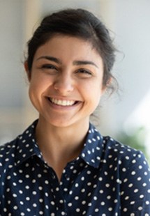 Young woman in polka dot shirt smiling in office