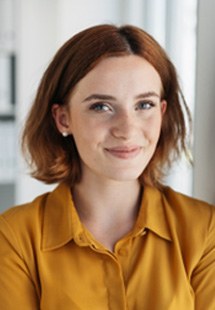 Smiling woman in orange shirt at office