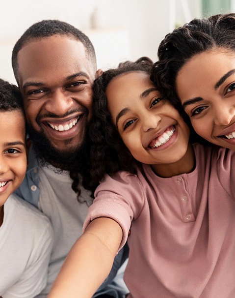 Parents and their children smiling after visiting a MetLife dentist in Garland