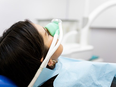 Patient breathing in nitrous oxide in treatment chair