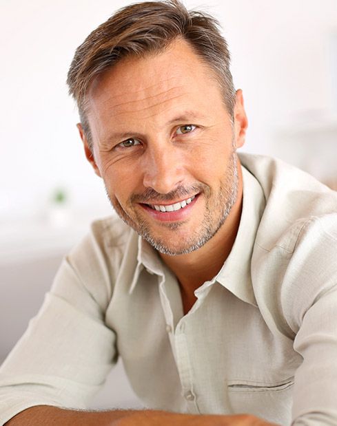 Man with healthy smile thanks to preventive dentistry