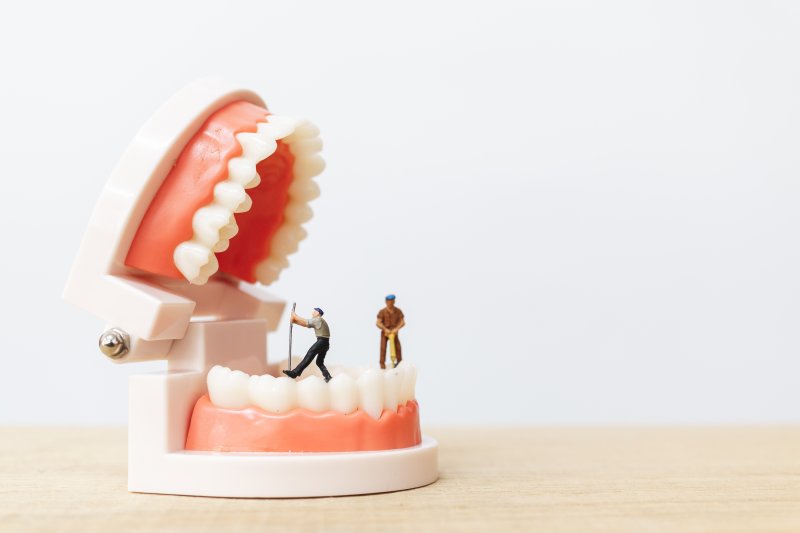 a set of dentures being fixed by toy men