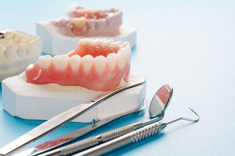 A closeup of a lower denture sitting on a platform