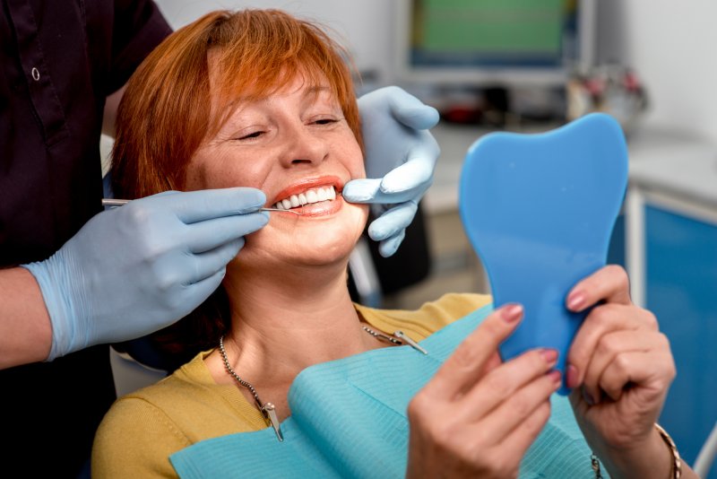 A senior woman admiring her new dental implants