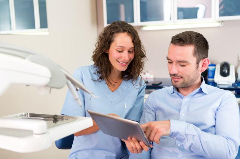Patient talking to dentist about dental insurance for dental implants