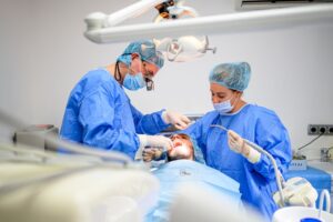 Dental team carefully performing dental implant surgery