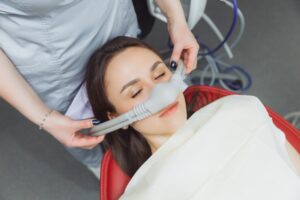Woman taking laughing gas at dentist's office.